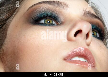 Macro closeup di parte femminile umana del make-up viso. Donna con naturale sera Vogue viso bellezza trucco. Ragazza con pelle perfetta e occhi blu sha