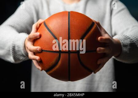 Primo piano di un giocatore di basket professionista che tiene una palla in mano. Atleta di basket di strada che si prepara alla competizione. Concetto di successo, scorin Foto Stock