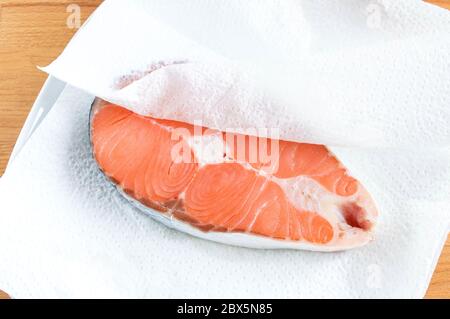 Bistecca di salmone su asciugamani da cucina. Il pesce rosso è preparato per cucinare. Foto Stock