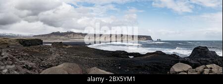 Roccia di basalto sulla spiaggia di sabbia nera come conosciuta come Reynisfjara spiaggia nella costa meridionale dell'Islanda in giorno di caduta della neve. Foto Stock