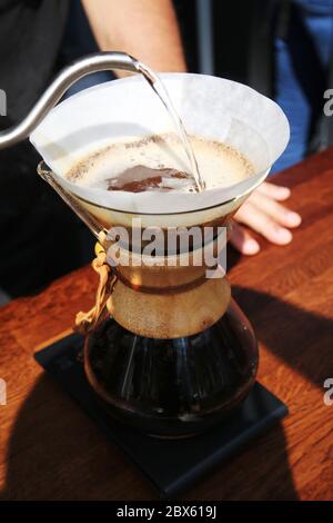 barista preparare il caffè al ristorante della caffetteria. l'erogazione di goccioline, caffè filtrato o il pour-over è un metodo che prevede l'erogazione di acqua sopra torrefatto, Foto Stock