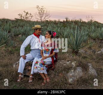 Merida, Yucatan/Messico-Febbraio 29,2020: Giovane coppia in abito tradizionale rubare un momento da soli su una piantagione di sisal Foto Stock