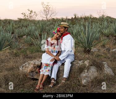 Merida, Yucatan/Messico-Febbraio 29,2020: Giovane coppia in abito tradizionale rubare un momento da soli su una piantagione di sisal Foto Stock