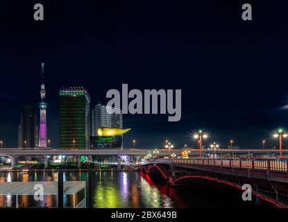 tokyo, giappone - marzo 25 2020: Vista notturna del ponte Azuma sul fiume Sumida e la scultura a forma di fiamma dorata della sede della birra Asahi dove si trovano Foto Stock