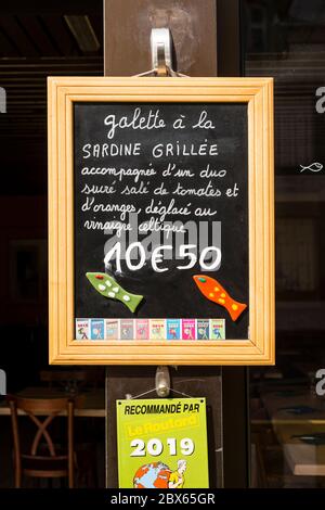 Menu manoscritto di sardine grigliate su lavagna esposto all'esterno di un ristorante, Cancale, Bretagna, Francia Foto Stock