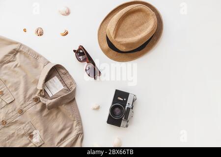 Set alla moda per viaggiatori di sesso maschile. Camicia da uomo e occhiali da sole isolati su sfondo bianco. Disposizione piatta, stile estivo. Foto Stock