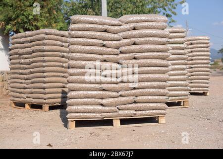 Molti sacchi che sono riempiti con pellet messo su pallet Foto Stock