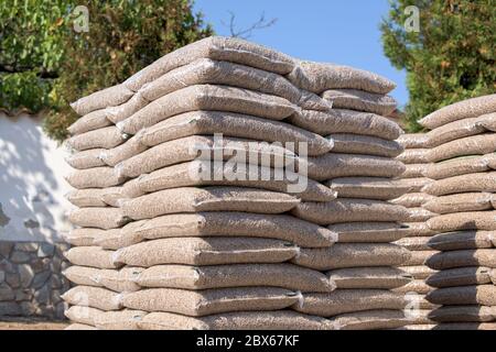 Molti sacchi che sono riempiti con pellet messo su pallet Foto Stock