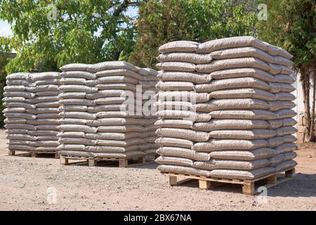 Molti sacchi che sono riempiti con pellet messo su pallet Foto Stock