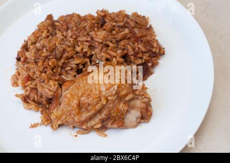 Pollo e riso iracheni cotti lentamente, noti come tbiet, serviti su un piatto bianco Foto Stock