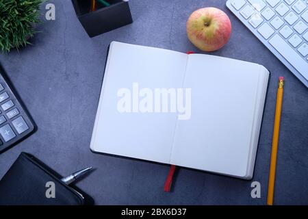 apple , diario aperto, libri e stazionario su sfondo di legno Foto Stock