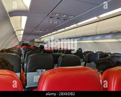 Passeggeri a bordo di un volo nazionale Air Asia per Bangkok in seguito alla ripresa dei voli interni durante la pandemia del coronavirus Foto Stock