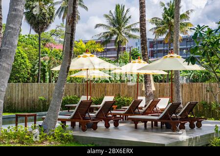 sedie a sdraio e ombrellone presso il lussuoso resort di villeggiatura Phuket Foto Stock