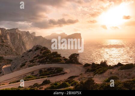 Panoramica delle scogliere di Capo Formentor sull'isola di Maiorca con le tonalità rossicci del tramonto con una strada tortuosa. Concetto di viaggio Foto Stock