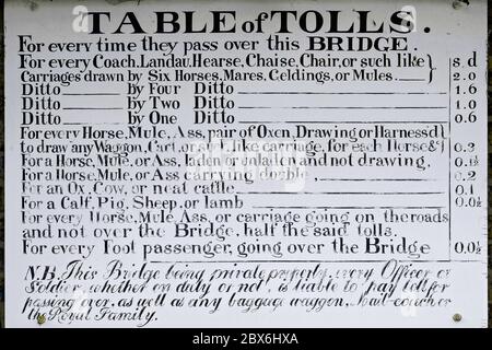 Insegna dipinta a mano con una lista di pedaggi o tasse, impostata dal Parlamento inglese nel 1776, per l'uso del primo ponte di ghisa del mondo che attraversa il fiume Severn a Ironbridge Gorge, Shropshire, Inghilterra. Il ponte è stato aperto al traffico nel 1781 e, come dimostra questa tabella di pedaggi sul Tollhouse accanto al ponte, anche il re e la regina non erano esenti dal pagamento dei pedaggi. Il ponte è stato progettato dall'architetto Thomas Farnolls Pritchard ed è stato forgiato e costruito dal maestro di ferro quacchero Abraham Darby III nella vicina Coalbrookdale. Foto Stock