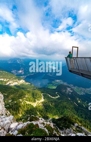 Donna sulla piattaforma di osservazione a 5 dita sulla cima del monte Krippenstein, godendo della vista mozzafiato sulla regione Salzkammergut, OÖ, Austria Foto Stock
