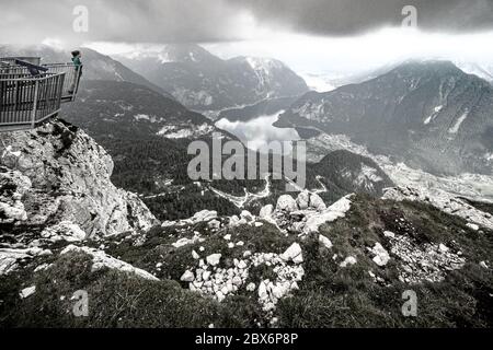 Donna sulla piattaforma di osservazione a 5 dita sulla cima del monte Krippenstein, godendo della vista mozzafiato sulla regione Salzkammergut, OÖ, Austria Foto Stock