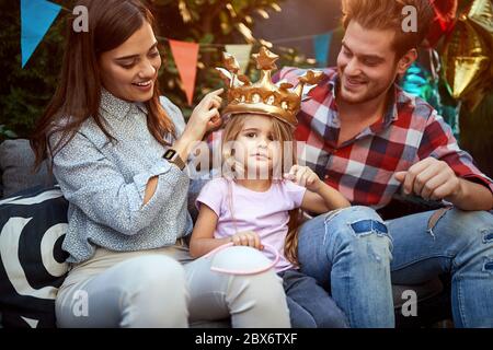 Felici genitori con figlia che festeggiano il compleanno Foto Stock