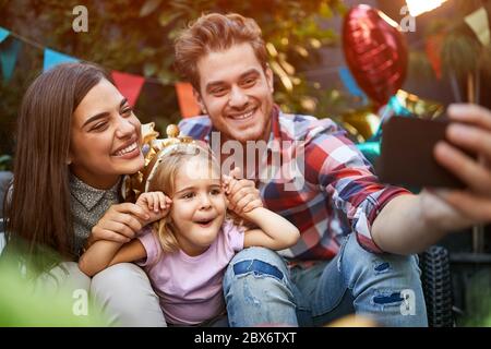 Famiglia con figlia che fa selfie e divertirsi Foto Stock