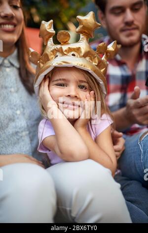 Carino birthaday ragazza con corona che celebra il compleanno in famiglia Foto Stock