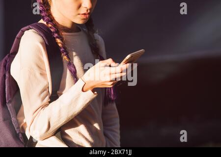 Bambino che usa lo smartphone al tramonto Foto Stock