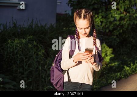 Bambino che usa lo smartphone al tramonto Foto Stock