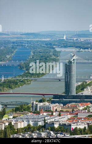 Vista da una collina vigna su Vienna, Austria, al Danubio con la Millennium Tower sulla destra e alcuni ponti. Foto Stock