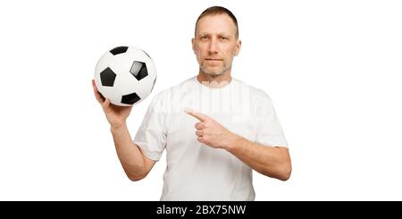 Un uomo tiene una palla di calcio e punta un dito su di essa. Foto Stock