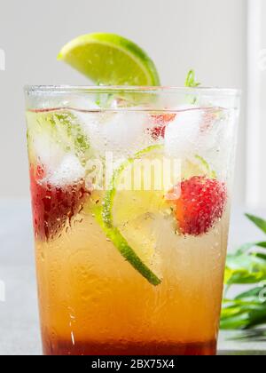 rinfrescante cocktail estivo con limonata di ghiaccio, lime, fragole e dragoncello Foto Stock