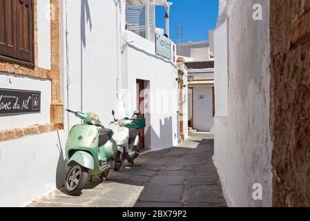 Rodi, Grecia - 14 maggio 2018: Scooter parcheggiati su una strada stretta nella città di Lindos. Isola di Rodi, Grecia Foto Stock