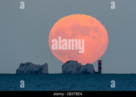 The Needles, Isola di Wight, Regno Unito. 5 giugno 2020. Regno Unito Meteo. La luna piena di fragole sorge da dietro gli aghi sull'isola di Wight al crepuscolo visto da Mudeford in Dorset. Immagine: Graham Hunt/Alamy Live News Foto Stock