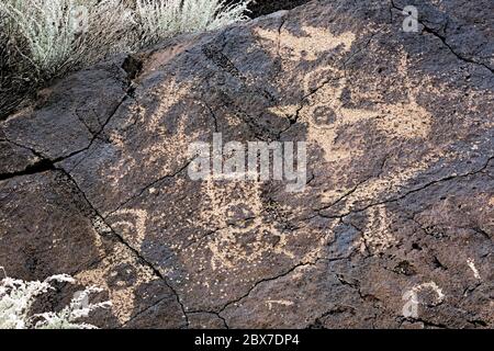NEW MEXICO - un pannello di petroglifi calpato su un masso basaltico dai Puebloans ancestrali trovati al Piedras Marcadas Canyon in Petroglyph NM. Foto Stock