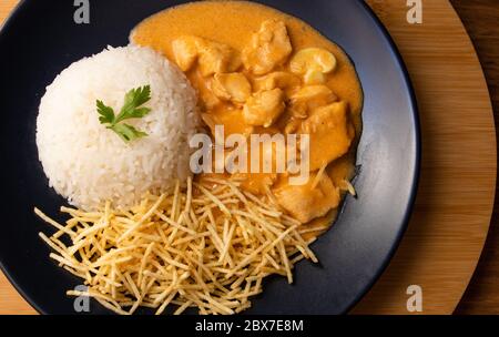 Strogonoff di pollo con riso e patatine fritte (bastoncini di patate) sul piatto. Lo stroganoff di pollo, è un piatto che proviene dalla cucina russa che in Brasile i Foto Stock