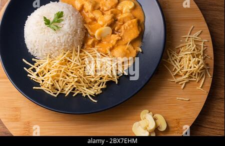 Strogonoff di pollo con riso e patatine fritte (bastoncini di patate) sul piatto. Lo stroganoff di pollo, è un piatto che proviene dalla cucina russa che in Brasile i Foto Stock