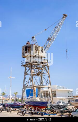 Grande gru arrugginita dilapidata nella zona marina di Portimao, Algarve occidentale, Portogallo meridionale in una giornata soleggiata con cielo blu Foto Stock