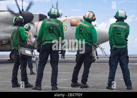 USS Theodore Roosevelt, Stati Uniti. 05 giugno 2020. I marinai della Marina statunitense si preparano a lanciare un aeromobile e-2C Hawkeye, assegnato alla Liberty Bells of Airborne Command and Control Squadron 115, dal ponte di volo della portaerei di classe Nimitz USS Theodore Roosevelt 5 giugno 2020 nel Mare delle Filippine. La nave è tornata in servizio dopo una lunga quarantena di equipaggio infetto da COVID e sta ora continuando a dispiegarsi alla settima flotta. Credito: MCS Dylan Lavin/U.S. Notizie dal vivo sulla Marina/Alamy Foto Stock