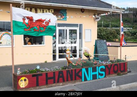 Bandiera gallese, e, Union Jack, bandiera con NHS grazie,Servizio sanitario Nazionale,supporto,poster,banner,di,supporto,pubblico,esterno,chiuso,Sands,cafe,ristorante,che,è,chiuso,a causa,Coronavirus,Covid 19,pandemic,in,Borth,mare,vacanza,resort,nord,di,Aberystwyth,Cereturismo occidentale ha attualmente aperto 5 miglia di viaggi, Galles e Galles.un numero di anziani.la politica di viaggi in Galles, non è aperto di vita, e Galles.un numero di persone anziana, è di persone anziana, non è di vita, ha aperto di vita, e di vita in Galles.un numero di persone anziana, è di vita in Galles.un numero di persone anziana, è di persone anziana, ha ma ha anche un'economia con molti che dipendono dal turismo, turisti. Foto Stock