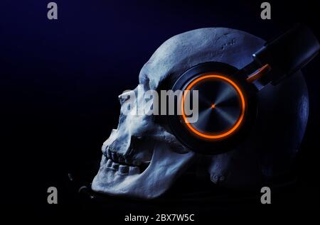 Cranio umano con cuffia a denti blu con evidenziazione a LED su un tavolo su sfondo nero. Foto Stock