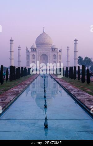 Taj Mahal e piscina riflettente in nebbia all'alba ad Agra, India Foto Stock