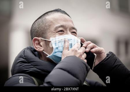 Uomo asiatico di mezza età che indossa una maschera medica Foto Stock