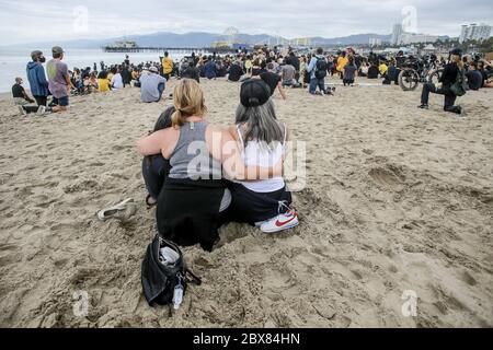 Santa Monica, Stati Uniti. 05 giugno 2020. Due manifestanti si tengono l'uno contro l'altro, mentre si ripagano rispetto a George Floyd durante la dimostrazione. I manifestanti hanno marciato dal molo di Venice Beach al molo di Santa Monica per onorare George Floyd e chiedere riforme per porre fine alla brutalità della polizia. Credit: SOPA Images Limited/Alamy Live News Foto Stock