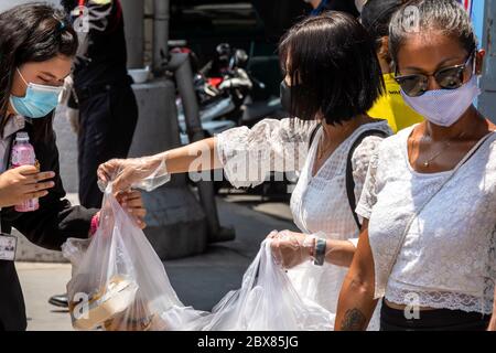 Volontari che danno cibo libero alle persone povere in banca alimentare durante la pandemia di Covid, Bangkok, Thailandia Foto Stock