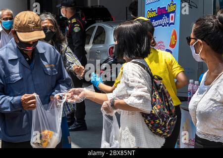 Volontari che danno cibo libero alle persone povere in banca alimentare durante la pandemia di Covid, Bangkok, Thailandia Foto Stock