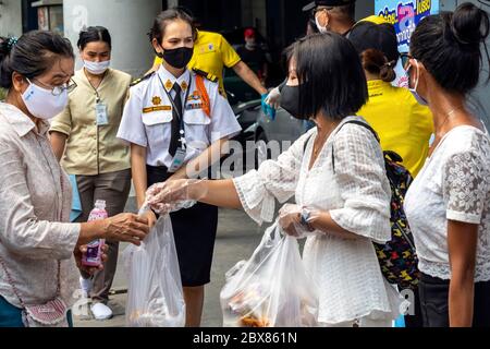 Volontari con maschere facciali che danno cibo libero durante la pandemia di Covid, Bangkok, Thailandia Foto Stock