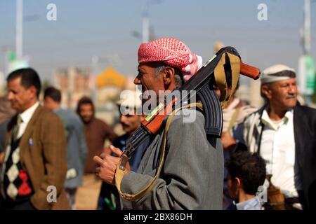 Armati uomini yemeniti tenere le loro armi come si riuniscono nella capitale Sanaa per mostrare il loro sostegno per gli Sciiti Huthi movimento contro l'Arabia-led inter Foto Stock