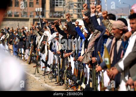 Armati uomini yemeniti tenere le loro armi come si riuniscono nella capitale Sanaa per mostrare il loro sostegno per gli Sciiti Huthi movimento contro l'Arabia-led inter Foto Stock