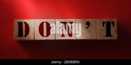 Non scrivere su un cubo di legno su sfondo rosso. Garanzia, divieto, divieto e divieto in ambito sociale, etico e commerciale Foto Stock