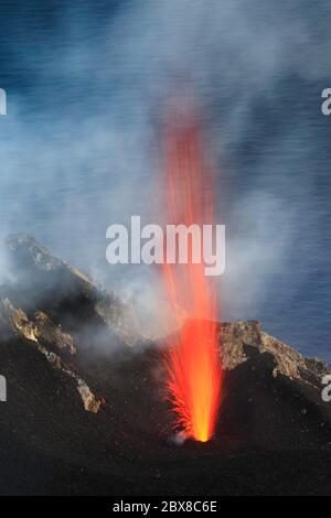 Schizzo di lava dettaglio sul vulcano Stromboli in cima al cratere con sfondo mare all'alba Foto Stock