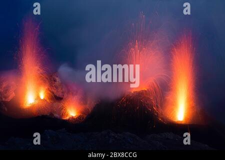 Vulcano Stromboli in una panoramica di una più grande eruzione di lava con esplosioni di magma sul cratere superiore all'alba Foto Stock