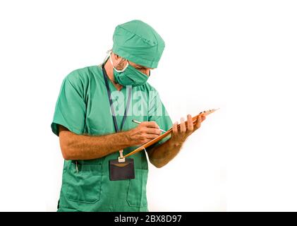 ritratto isolato di attraente e bello medico o infermiere dell'ospedale in chirurgia bouffant cappello e scrub medico tenendo appunti di lavoro Foto Stock